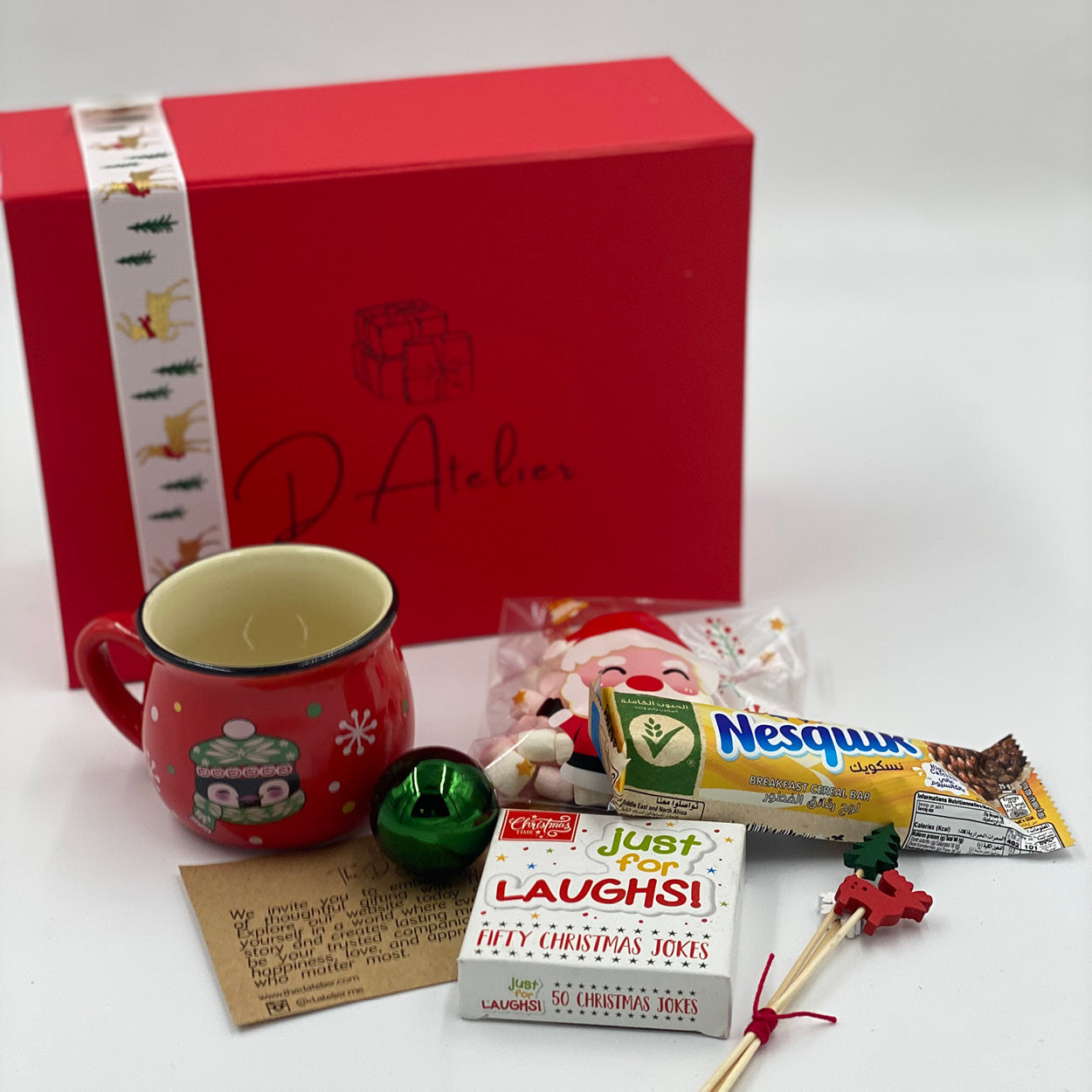 Kids box for Christmas, small porcelain Christmas cup for kids, a cereal bar, marshmallow, fun cards, and Christmas ornaments