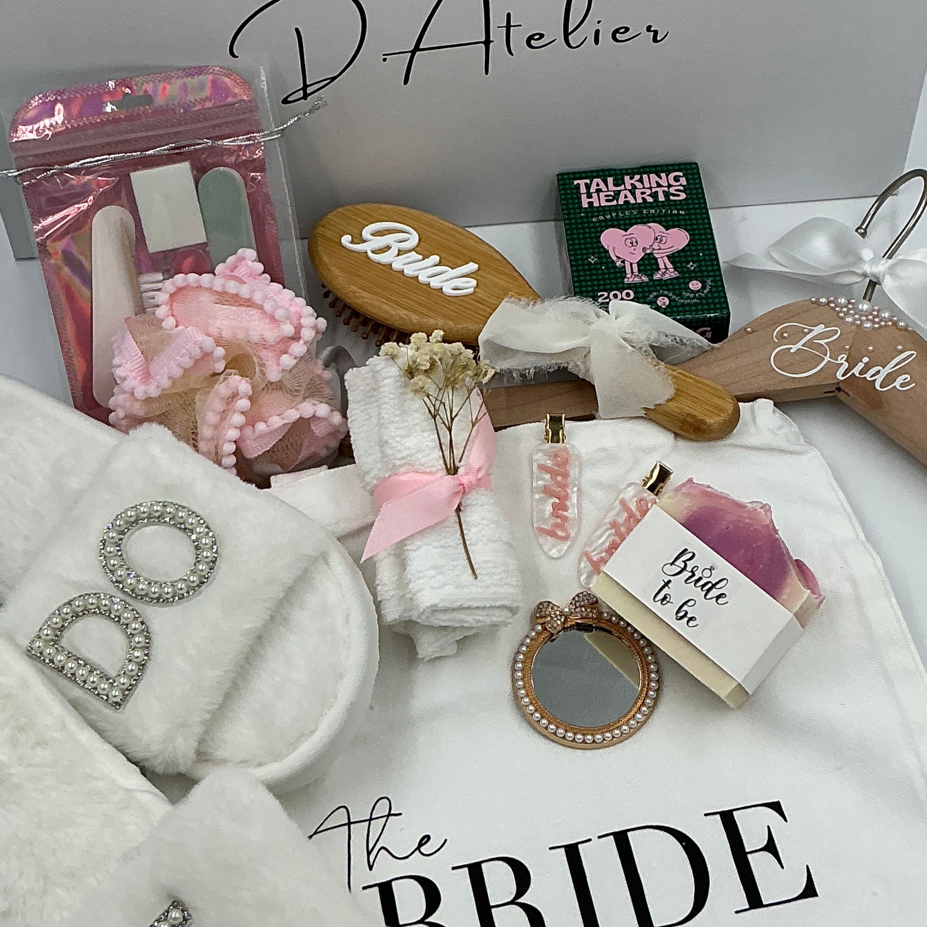 Collection of bridal-themed items including a hairbrush, mirror, and decorative boxes on a white surface.