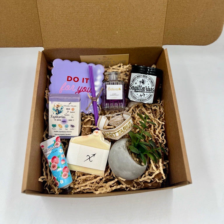 Sagittarius Gift box with various items including a candle, soap, and stationery on a white background.