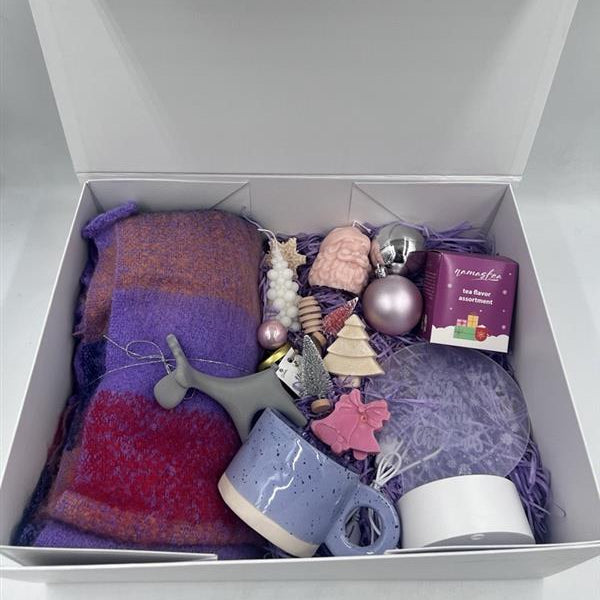 Gift box with a purple and red scarf, mug, and decorative items.