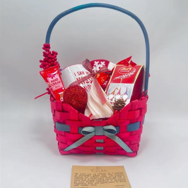 Gift basket with various items including a mug, Hand Cream, Hot Chocolate, Lindt Chocolate box, Christmas Tree Scented Candle, Christmas Sock and ornaments