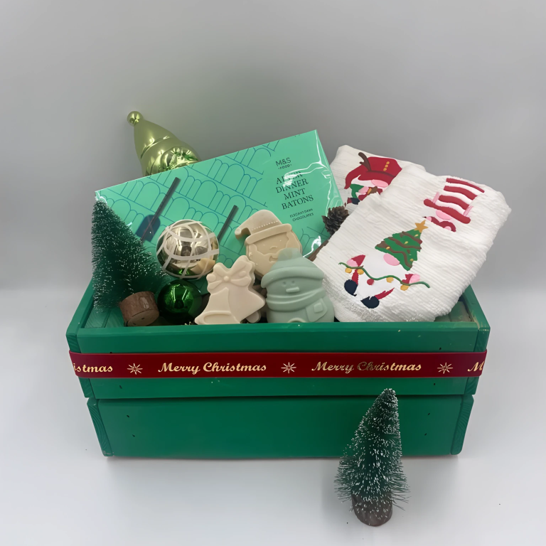 Decorative Christmas items including a green wooden box, small tree, Chocolate Batons box, Christmas towels, natural handmade soaps, and Christmas ornaments