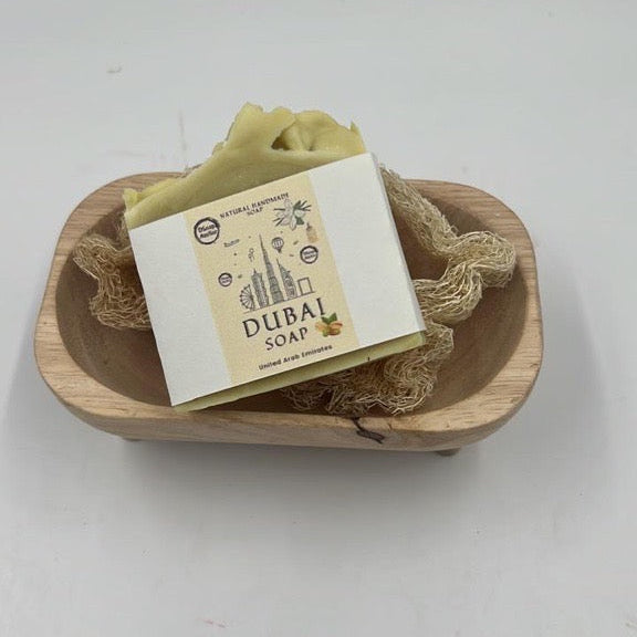 Bar of soap with a label in a wooden dish on a white background. Enjoy our pistachio Bliss Soap! The Dubai Soap!

Crafted with pistachio essential oil, coconut milk, and pure oils.

What soap is to the body, laughter is to the soul.