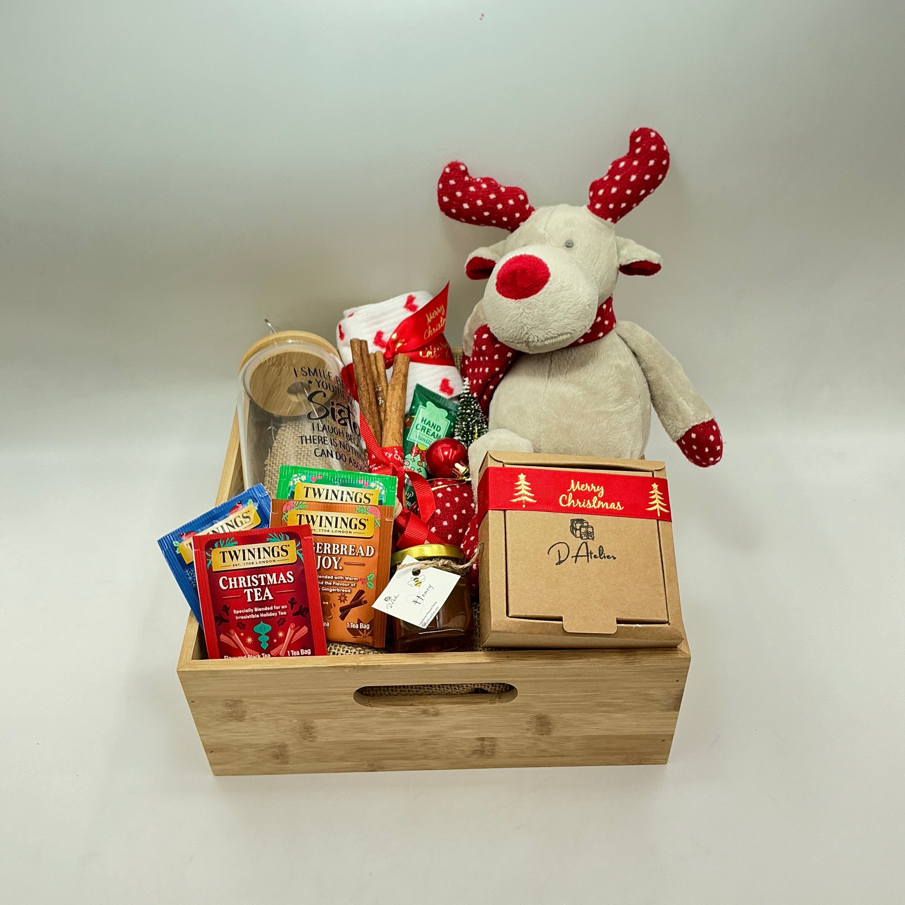 A hamper for my sister and best friend, a plus reindeer, Christmas ornaments, a glass tumbler, hand cream, cinnamon sticks, honey jar, 4 tea sachets, natural handmade soap, socks.