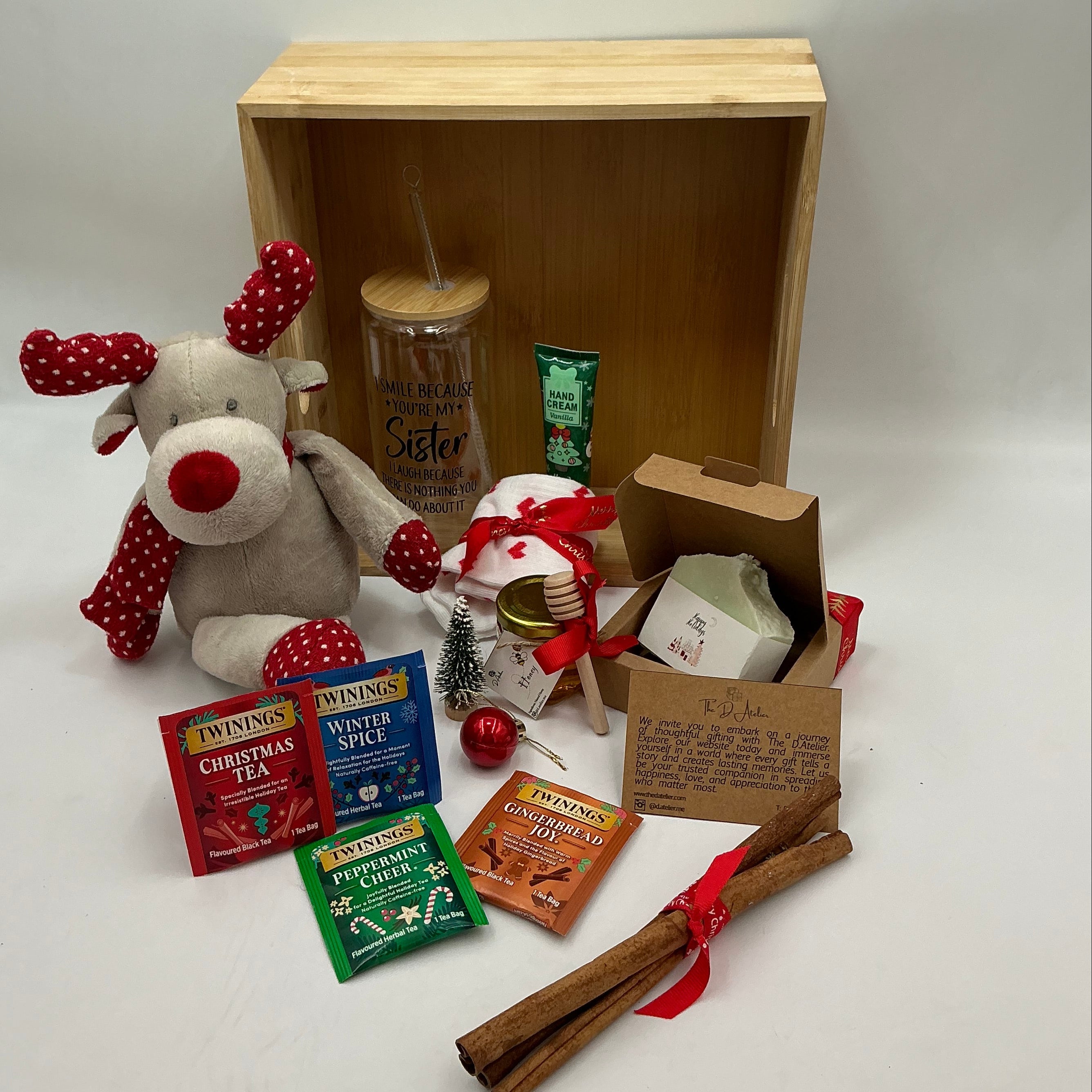 A hamper for my sister and best friend, a plus reindeer, Christmas ornaments, a glass tumbler, hand cream, cinnamon sticks, honey jar, 4 tea sachets, natural handmade soap, socks.