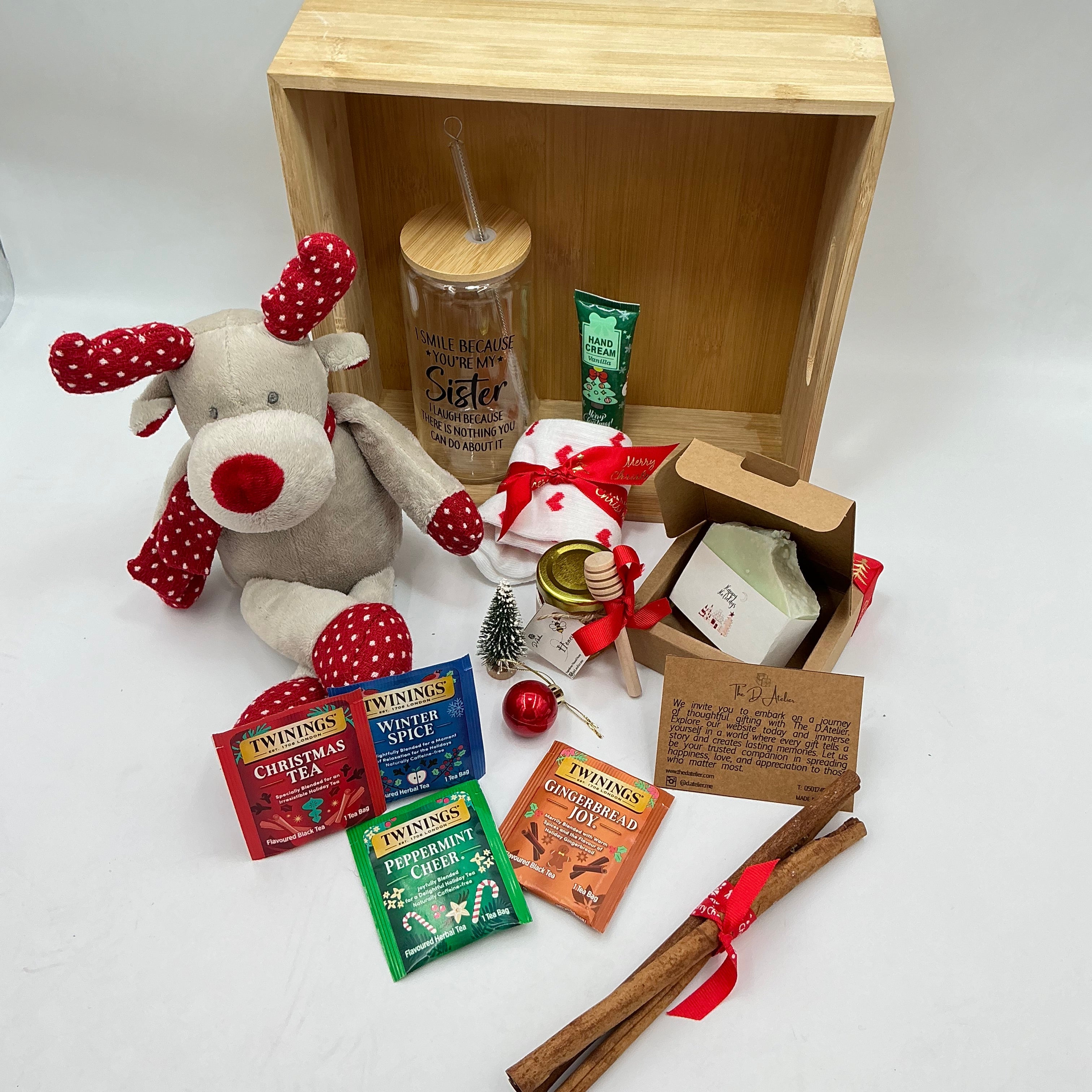 A hamper for my sister and best friend, a plus reindeer, Christmas ornaments, a glass tumbler, hand cream, cinnamon sticks, honey jar, 4 tea sachets, natural handmade soap, socks.