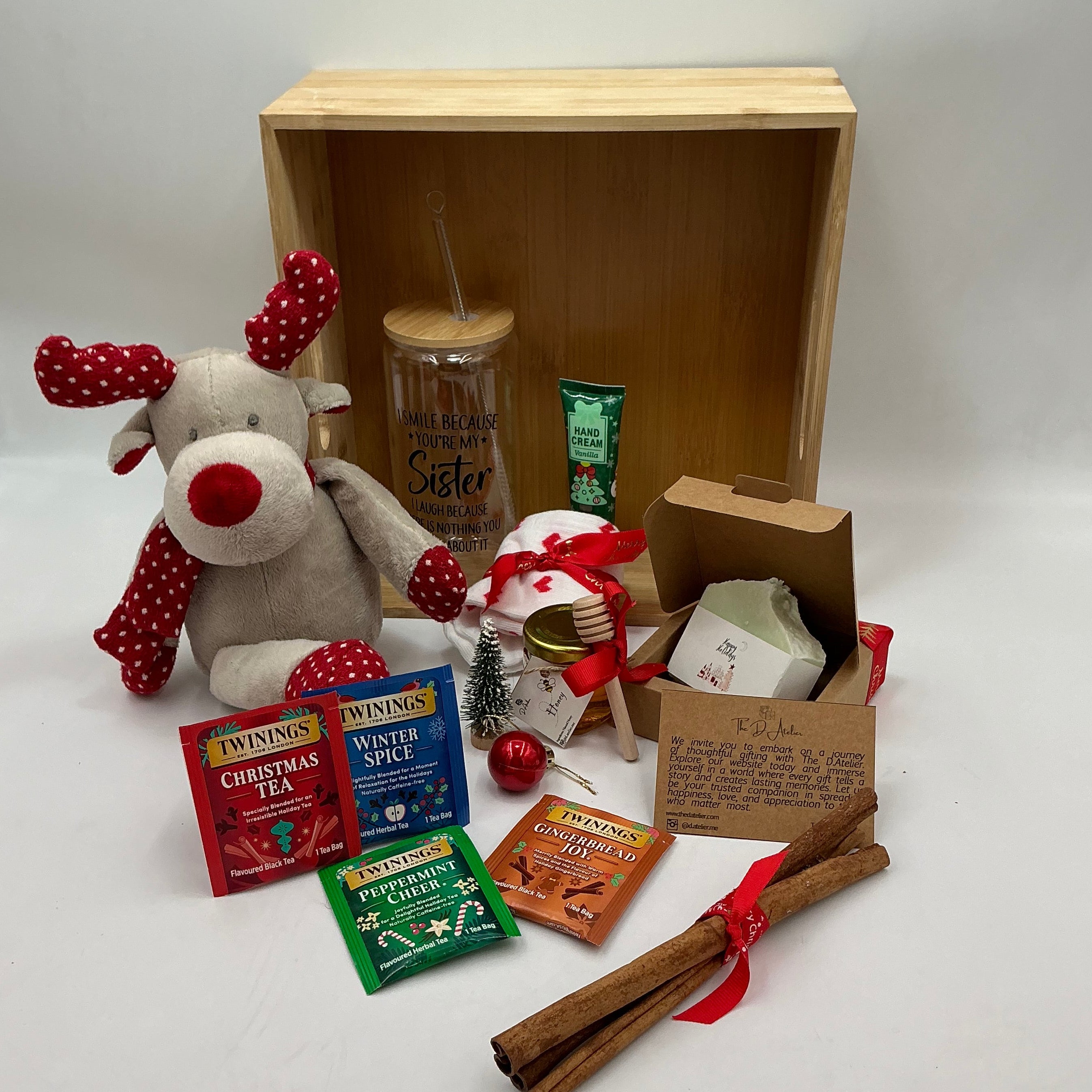 A hamper for my sister and best friend, a plus reindeer, Christmas ornaments, a glass tumbler, hand cream, cinnamon sticks, honey jar, 4 tea sachets, natural handmade soap, socks.