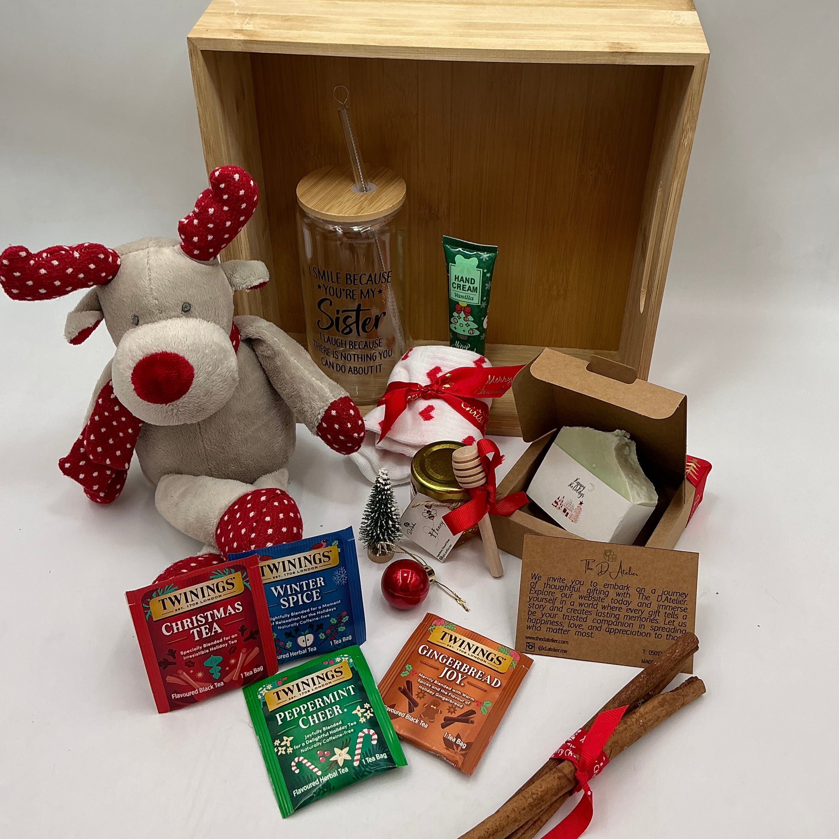 A hamper for my sister and best friend, a plus reindeer, Christmas ornaments, a glass tumbler, hand cream, cinnamon sticks, honey jar, 4 tea sachets, natural handmade soap, socks.