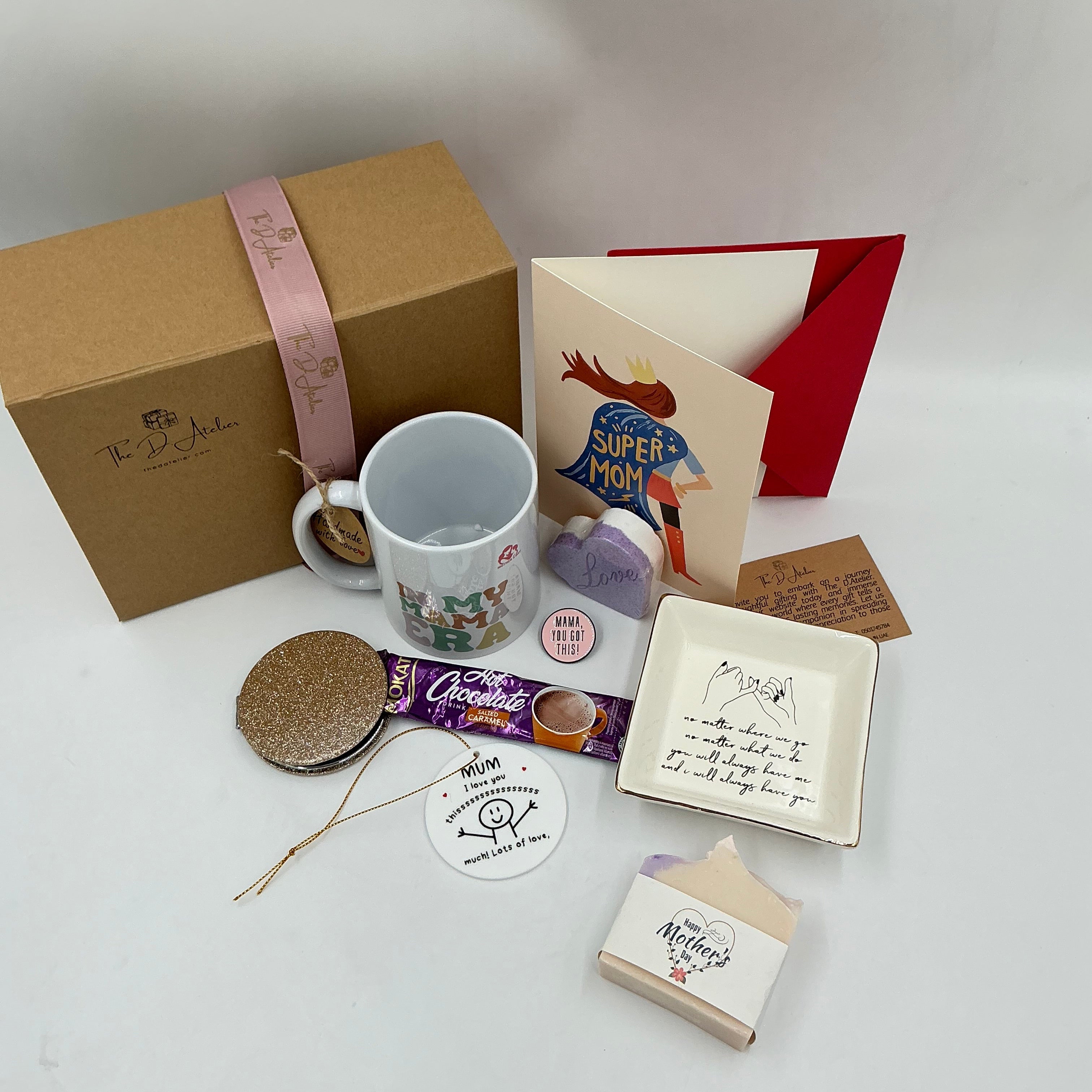 Collection of gift items including a mug, cards, and a box on a light background
