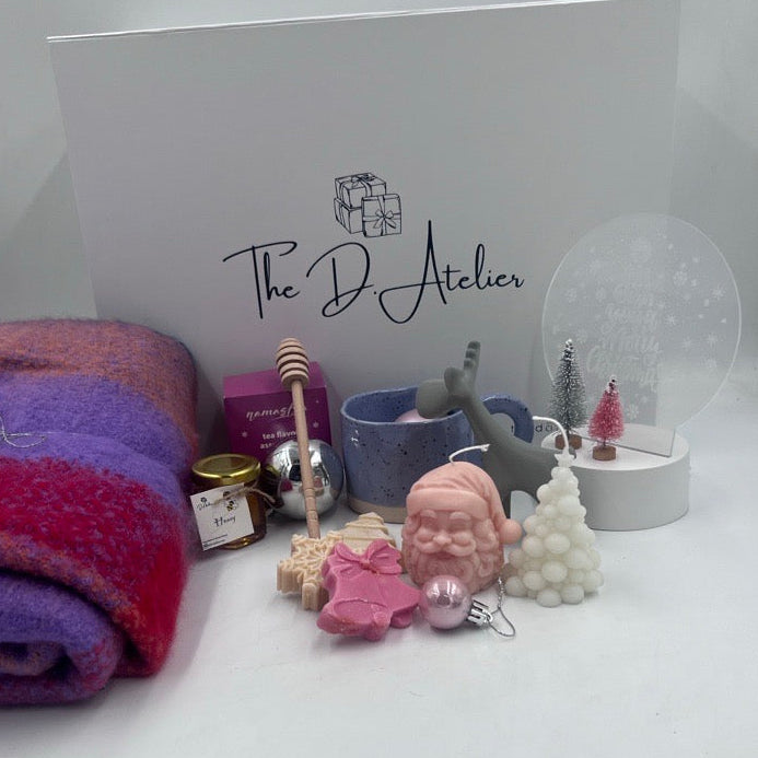 This beautiful hamper is the perfect gift for your loved ones this holiday season, combining warmth, elegance, and festive cheer.&nbsp;

Inside this charming gift hamper, you will find:

- Pashmina Cotton Scarf: A luxurious blend of pink and purple hues, this soft scarf adds a touch of elegance and comfort, perfect for keeping warm during chilly winter days.
- Handmade Christmas Candles: Crafted with care, these candles feature delightful Christmas designs that will infuse any space with a cozy and inviting
