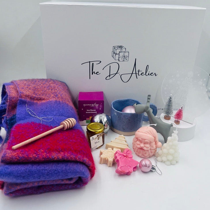 This beautiful hamper is the perfect gift for your loved ones this holiday season, combining warmth, elegance, and festive cheer;

Inside this charming gift hamper, you will find:

- Pashmina Cotton Scarf: A luxurious blend of pink and purple hues, this soft scarf adds a touch of elegance and comfort, perfect for keeping warm during chilly winter days.
- Handmade Christmas Candles: Crafted with care, these candles feature delightful Christmas designs that will infuse any space with a cozy and inviting