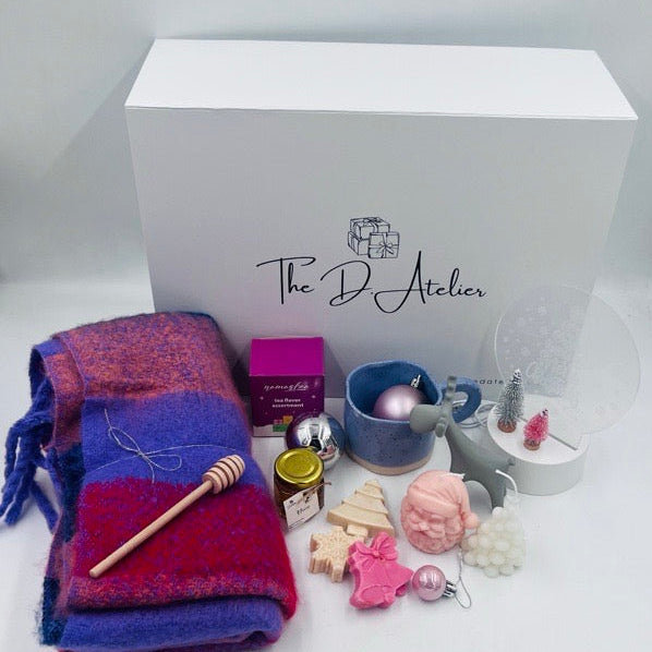 This beautiful hamper is the perfect gift for your loved ones this holiday season, combining warmth, elegance, and festive cheer 

Inside this charming gift hamper, you will find:

- Pashmina Cotton Scarf: A luxurious blend of pink and purple hues, this soft scarf adds a touch of elegance and comfort, perfect for keeping warm during chilly winter days.
- Handmade Christmas Candles: Crafted with care, these candles feature delightful Christmas designs that will infuse any space with a cozy and inviting