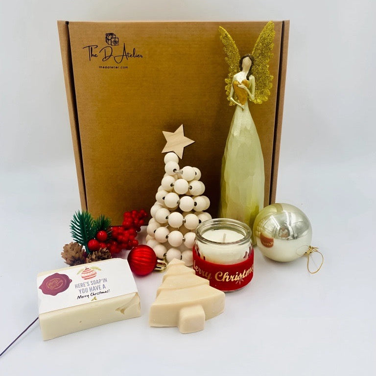 Christmas-themed gift set with a candle, soap, and decorative items on a white background.