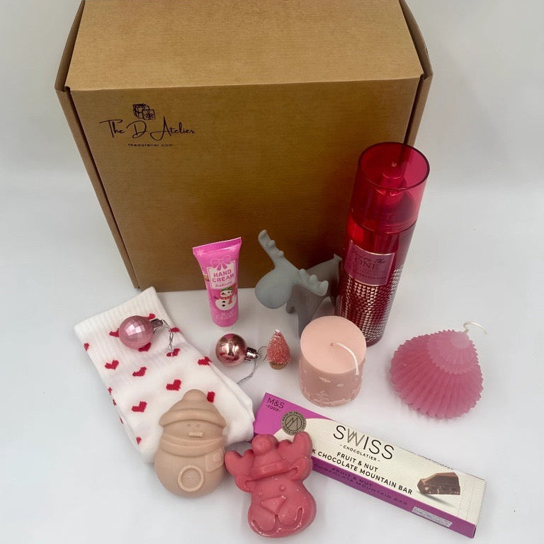 Collection of products including a box, hand ream, pink Candles, Natural handmade soaps, Body Spray from Victoria's secret, heart shape sock, chocolate from M&S. 