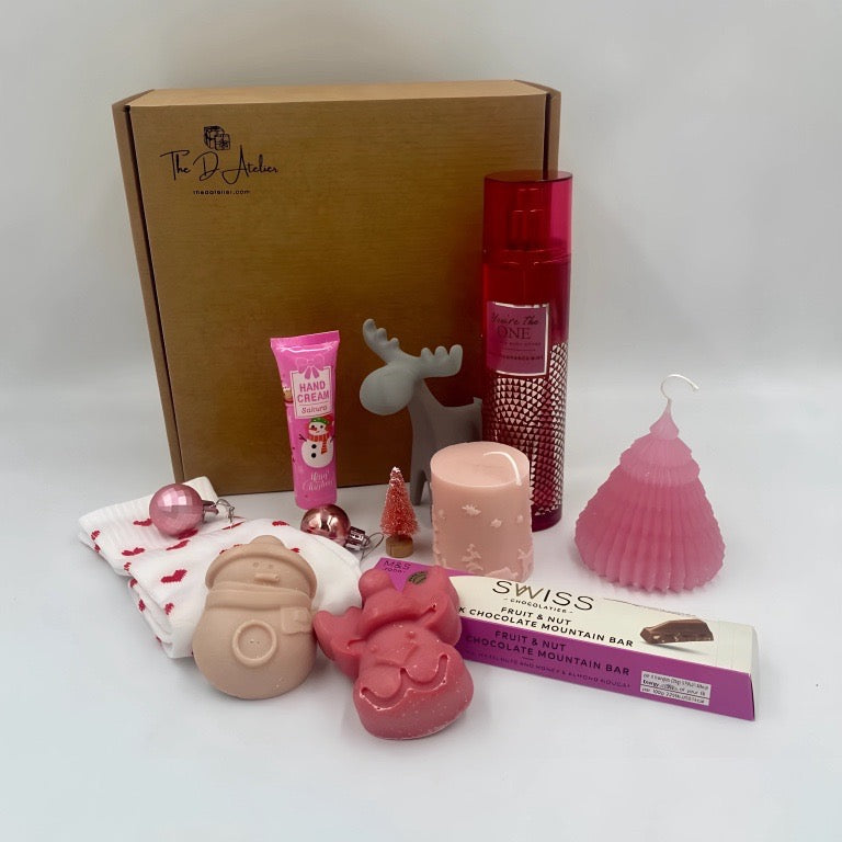 Collection of products including a box, hand ream, pink Candles, Natural handmade soaps, Body Spray from Victoria's secret, heart shape sock, chocolate from M&S. 