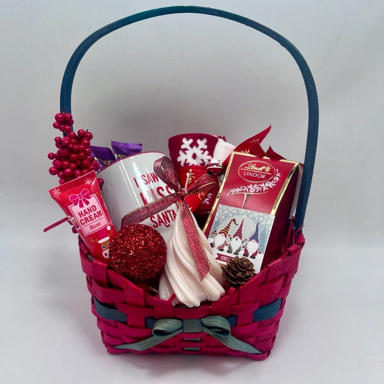 Gift basket with various items including a mug, Hand Cream, Hot Chocolate, Lindt Chocolate box, Christmas Tree Scented Candle, Christmas Sock and ornaments