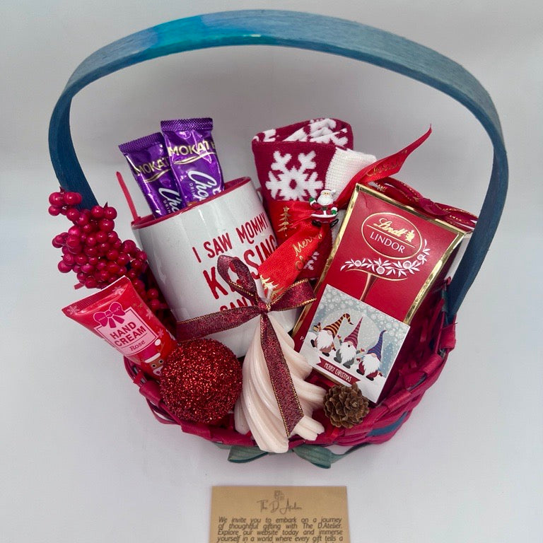 Gift basket with various items including a mug, Hand Cream, Hot Chocolate, Lindt Chocolate box, Christmas Tree Scented Candle, Christmas Sock and ornaments