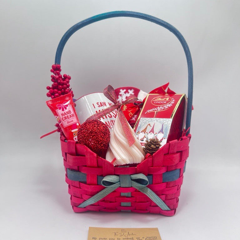 Gift basket with various items including a mug, Hand Cream, Hot Chocolate, Lindt Chocolate box, Christmas Tree Scented Candle, Christmas Sock and ornaments
