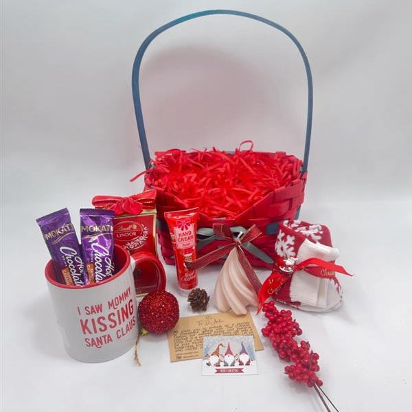 Gift basket with various items including a mug, Hand Cream, Hot Chocolate, Lindt Chocolate box, Christmas Tree Scented Candle, Christmas Sock and ornaments