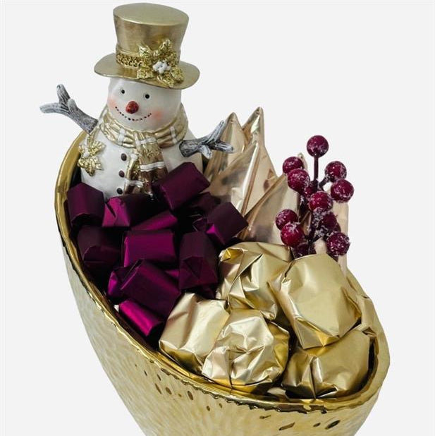 Decorative gift basket with a snowman, gold and purple ribbons, and berries on a white background